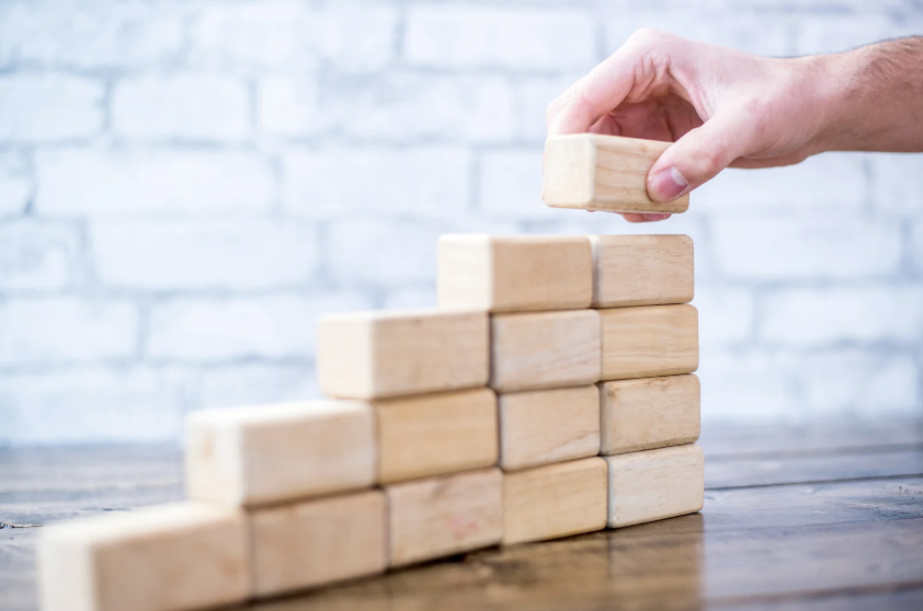 person placing blocks in the shape of stairs